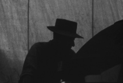 Oppenheimer hunched over the Trinity bomb, engaged in final preparations for the test